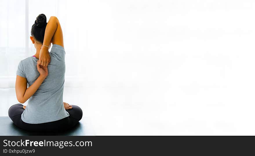 Female doing stretching exercises yoga practice. Hands behind back, sitting in Vajrasana pose with hands hooked behind the back.rear view,Concept of healing body and spirit,panoramic banner with copy space. Female doing stretching exercises yoga practice. Hands behind back, sitting in Vajrasana pose with hands hooked behind the back.rear view,Concept of healing body and spirit,panoramic banner with copy space