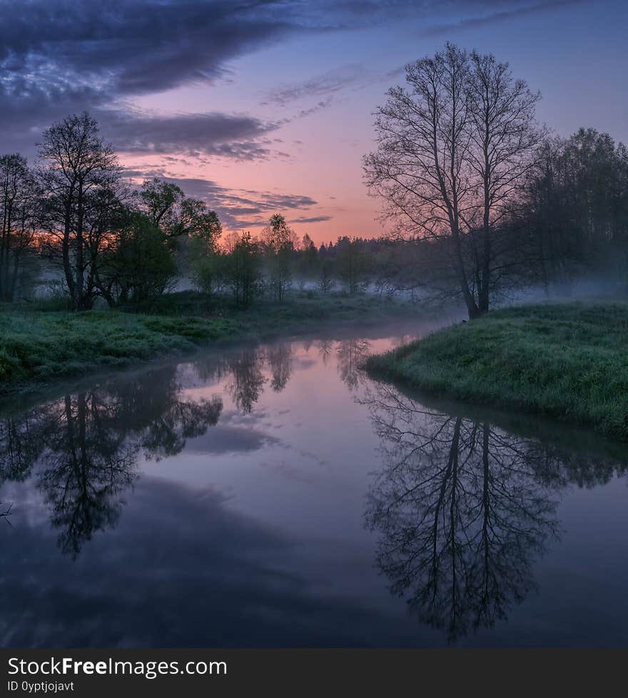 May sunrise and a small river with fog in the very early spring morning