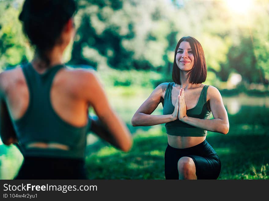 Women Doing Yoga by the Lake