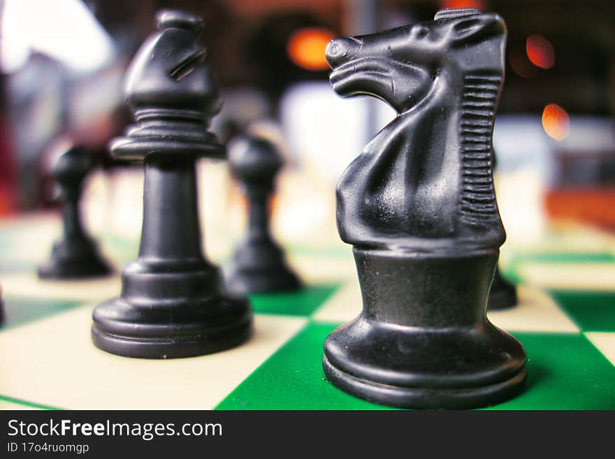 knight chess piece in foreground on chess board