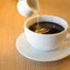 Cream being poured into a cup of coffee.