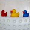 A rubber bathmat and three rubber duckies.