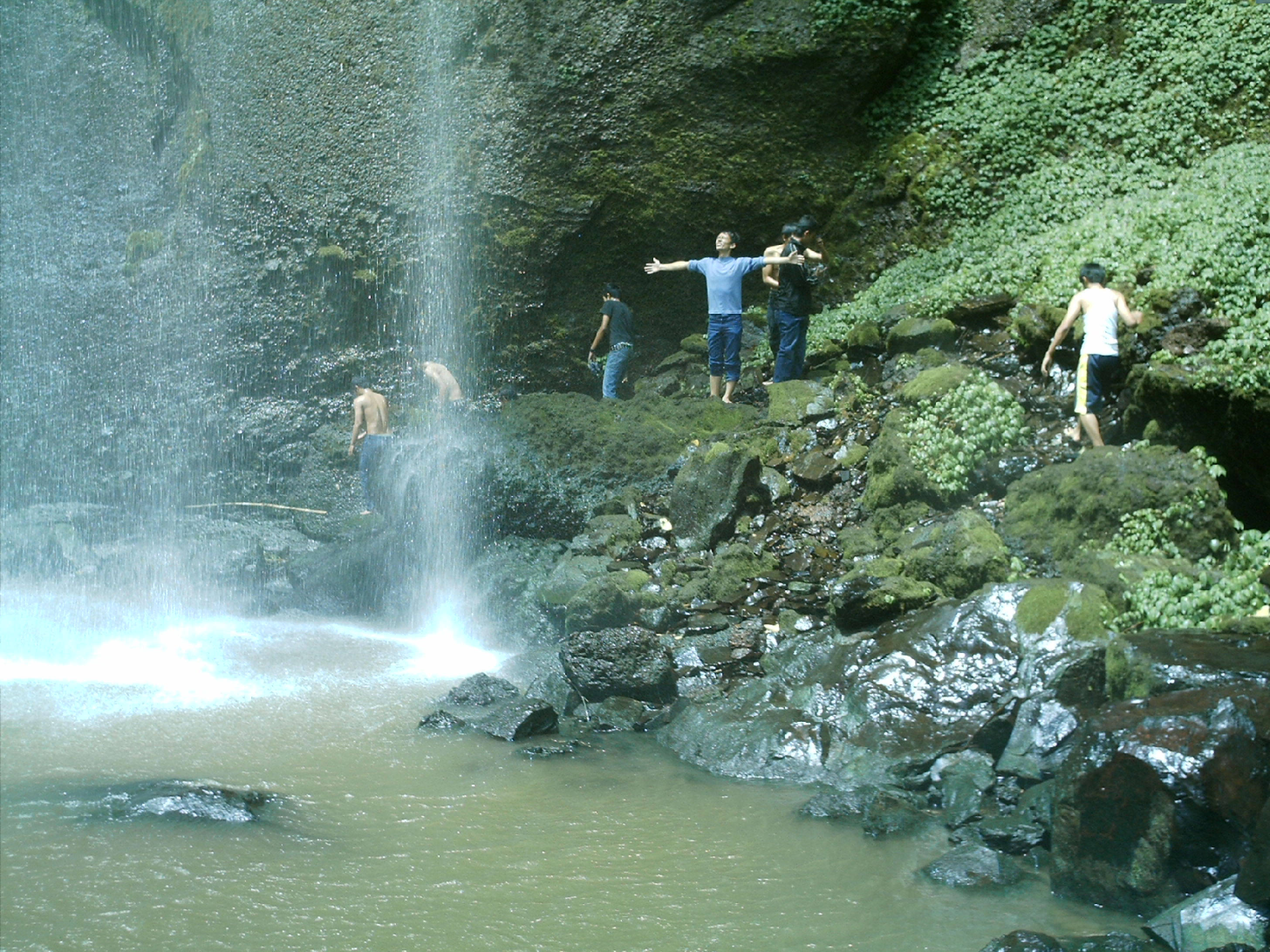 People under the waterfall photo