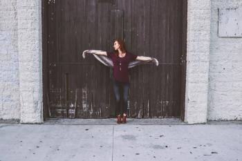 Woman Leaning on Brown Wooden Door