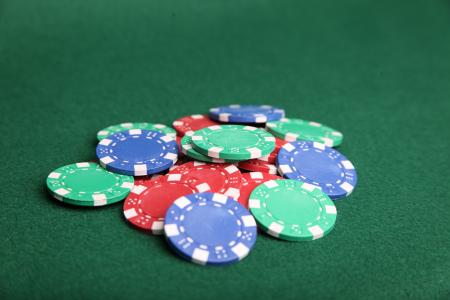 Pile of poker chips on green felt.