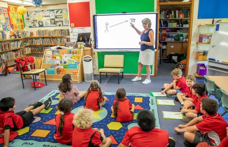 School kids in class looking at the whiteboard, 