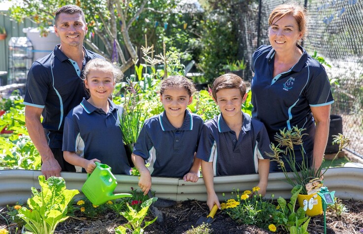 3 school kids with their teachers in the garden