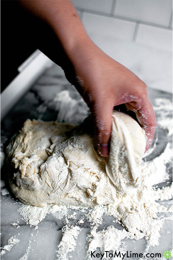 Hand kneading pizza dough ball.