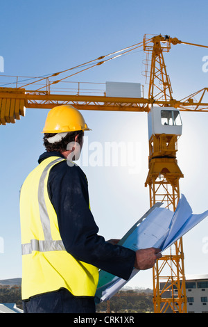 Worker reading blueprints on site Stock Photo