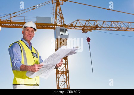 Worker reading blueprints on site Stock Photo