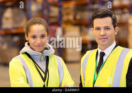 Businessman and worker smiling in warehouse Stock Photo