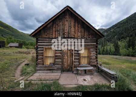 Rustic log cabin in valley Stock Photo