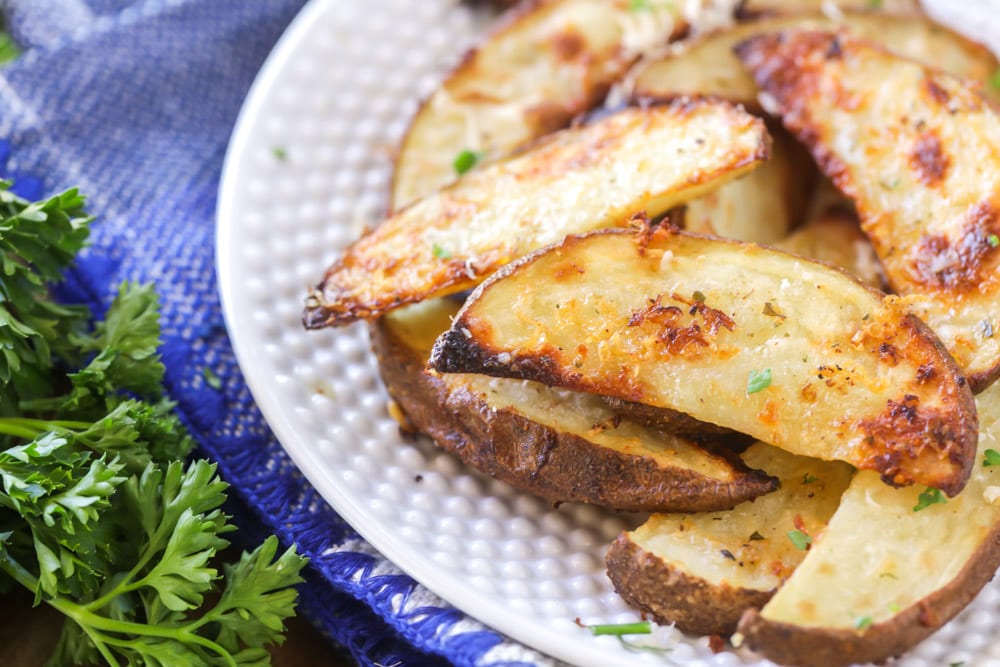 A white plate filled with potato wedges.