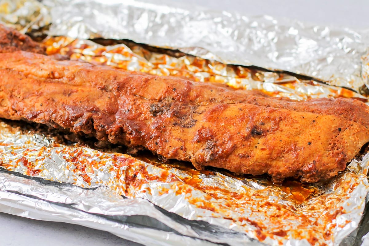 Unwrapping ribs from tinfoil after cooking.