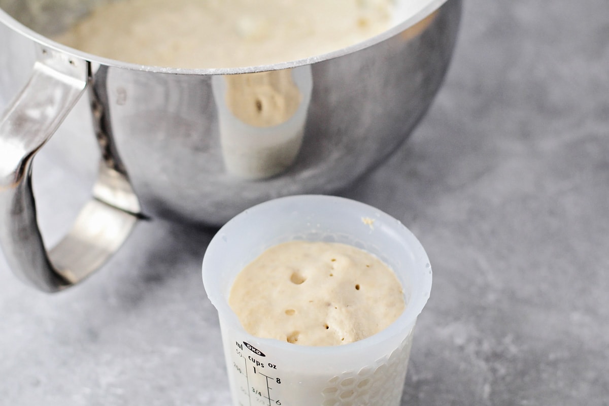 Adding activated yeast to bread dough.