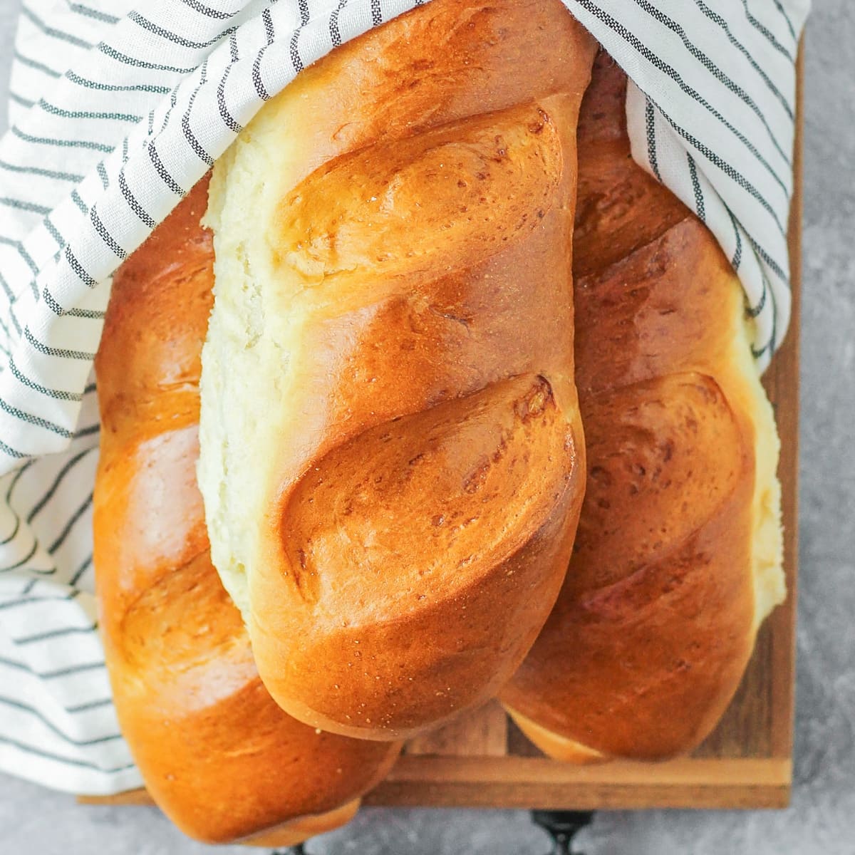 Homemade French bread loves in dish towel.