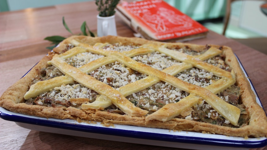 A picture of a finished rabbit pie with pastry lattice sitting in a baking dish on a counter.