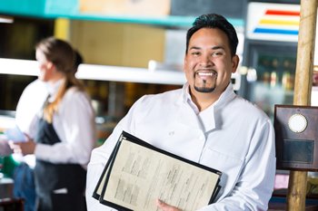 Restaurant owner holding new MenuCoverMan.com menu jackets.