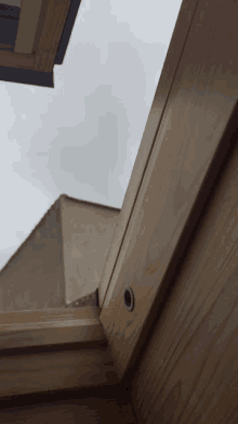 looking up at the sky through a window in a wooden building