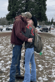 a man and a woman are kissing in the snow