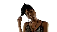 a woman with dreadlocks is wearing a black top and a necklace