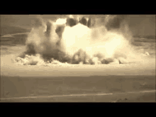 a large explosion is taking place in the middle of a desert .