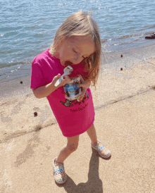 a little girl wearing a pink t-shirt that says tyler shore park