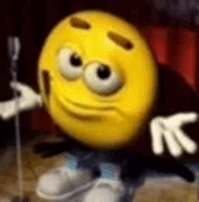 a cartoon smiley face is holding a microphone and wearing a m & ms costume .