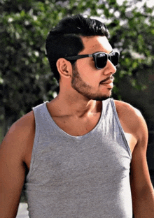 a man wearing sunglasses and a tank top