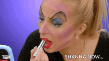a woman with makeup on her face is applying red lipstick