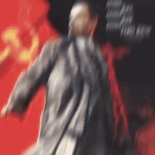 a blurry picture of a man standing in front of a red and black background with the number 33 on it