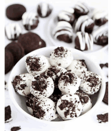 a white bowl filled with oreo truffles surrounded by oreos