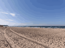 a beach with a blue sky and a few waves