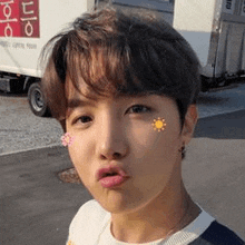 a close up of a person 's face with a flower on his cheek .