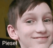 a close up of a young boy making a funny face with the name pieset .