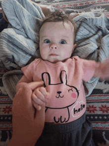 a baby wearing a pink hello bunny shirt