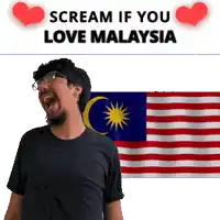 a man with glasses is screaming in front of a malaysia flag