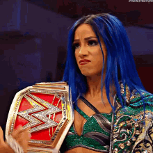 a woman with blue hair is holding a wrestling belt