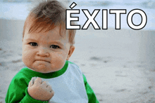 a baby in a green and white shirt with the word exito on the bottom