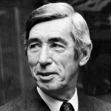 a black and white photo of an older man wearing a suit and tie .