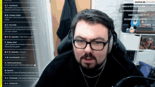 a man wearing glasses and headphones sits in front of a screen that says ' dafol88 ' on it