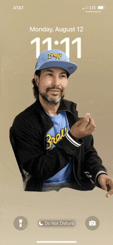 a phone screen shows a man wearing a hat and a shirt that says brewers