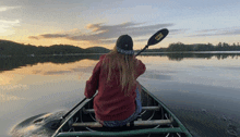 a person in a canoe with a paddle that says ' ncl ' on it