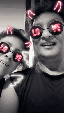 a man and woman wearing sunglasses that say love on them