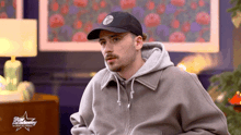 a man wearing a black hat and a grey hoodie with the word star academy on the front