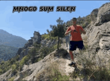 a man is standing on top of a rocky cliff .