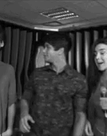 a group of people are standing in front of a microphone in a room .