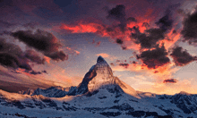 a snow covered mountain with a cloudy sky in the background