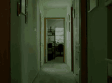 a dark hallway with a bunk bed in the corner and a desk in the other room .