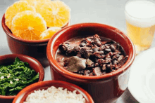 a bowl of food next to a glass of beer